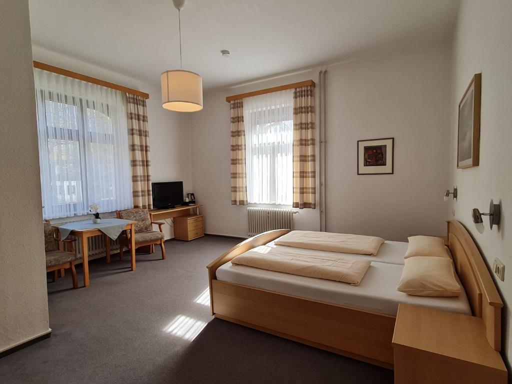 巴特莱辛哈尔加尼施泰尔马克旅馆的一间卧室设有一张床和一间客厅。