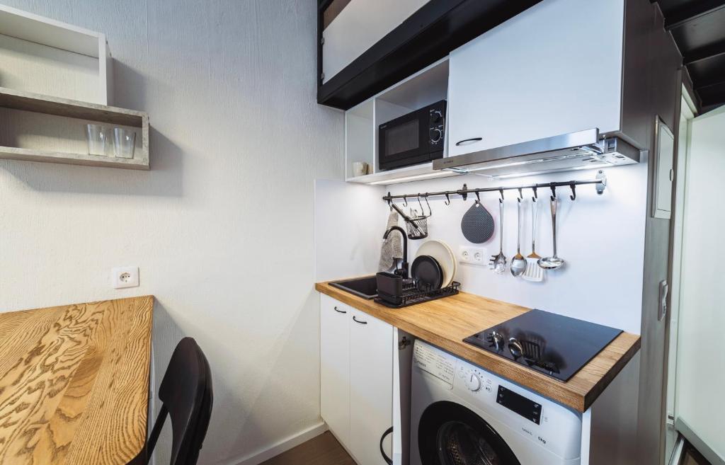 塔林City Apartments的一个带水槽和洗衣机的小厨房