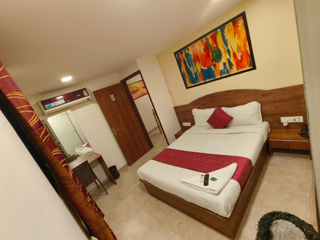 孟买Hotel Beach Crown Juhu的一间卧室配有一张带红色毯子的大床