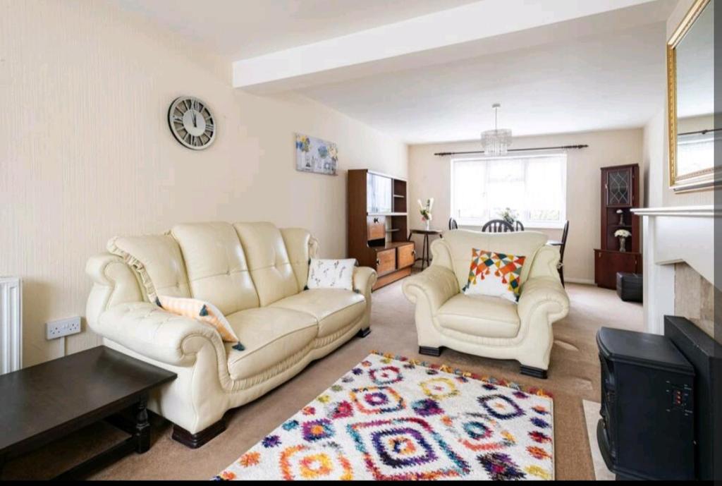 伦敦London Stratford Holiday Home的客厅配有2张白色沙发和壁炉