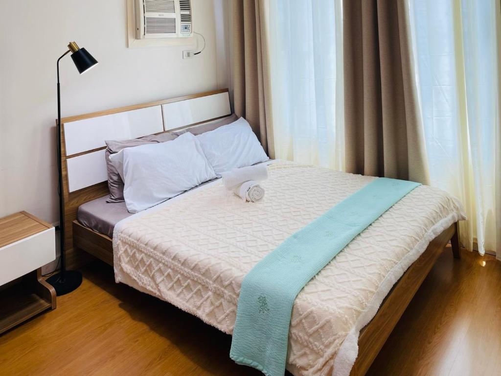 马尼拉8 Adriatico的一间卧室配有一张带蓝色毯子的床