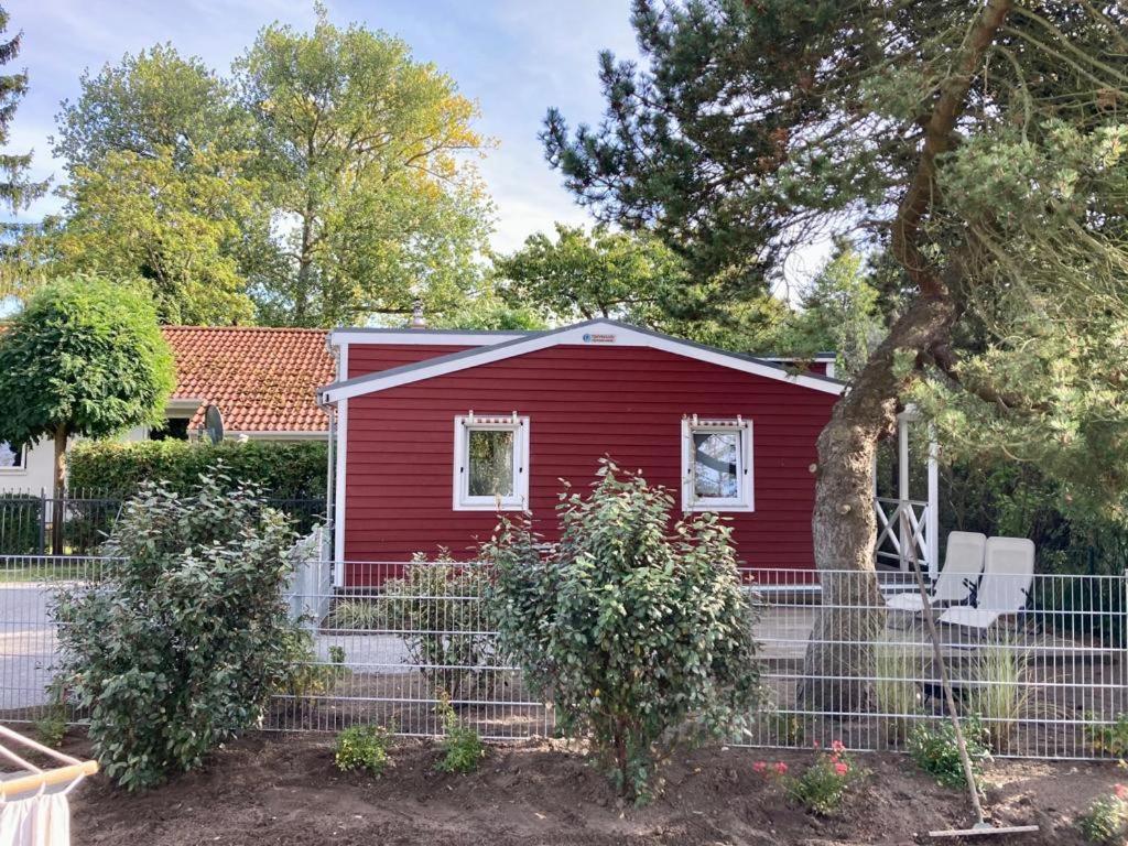 黑灵斯多夫Tiny House am Meer的前面有栅栏的红色房子