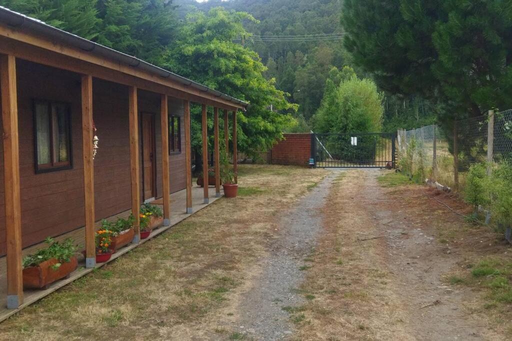 瓦尔迪维亚Chalet Valdivia的一条土路,靠近一座带栅栏的房子