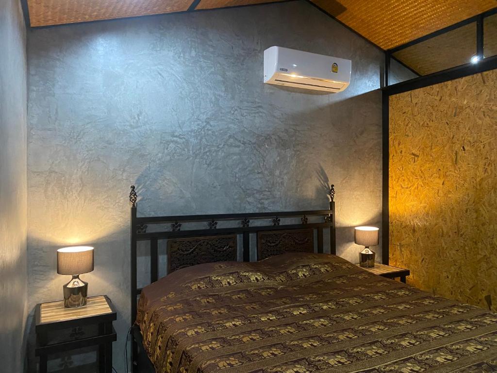 Koh Loneแครินโฮมสเตร์的一间卧室配有一张床和两个带灯的床头柜