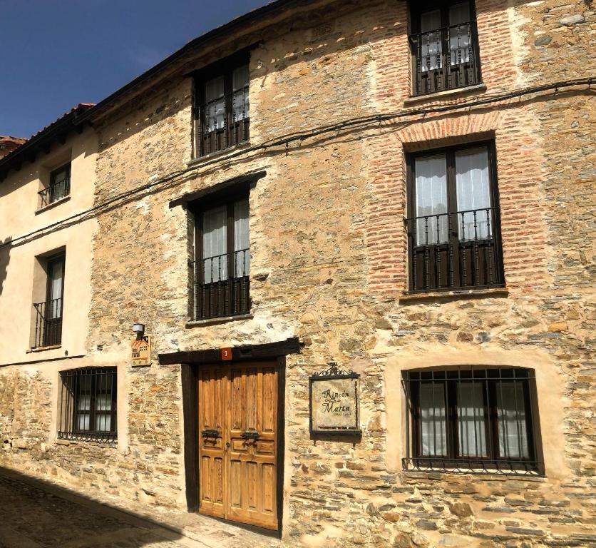 YanguasHotel Rural El Rincón de Marta的一座古老的砖砌建筑,设有木门和窗户