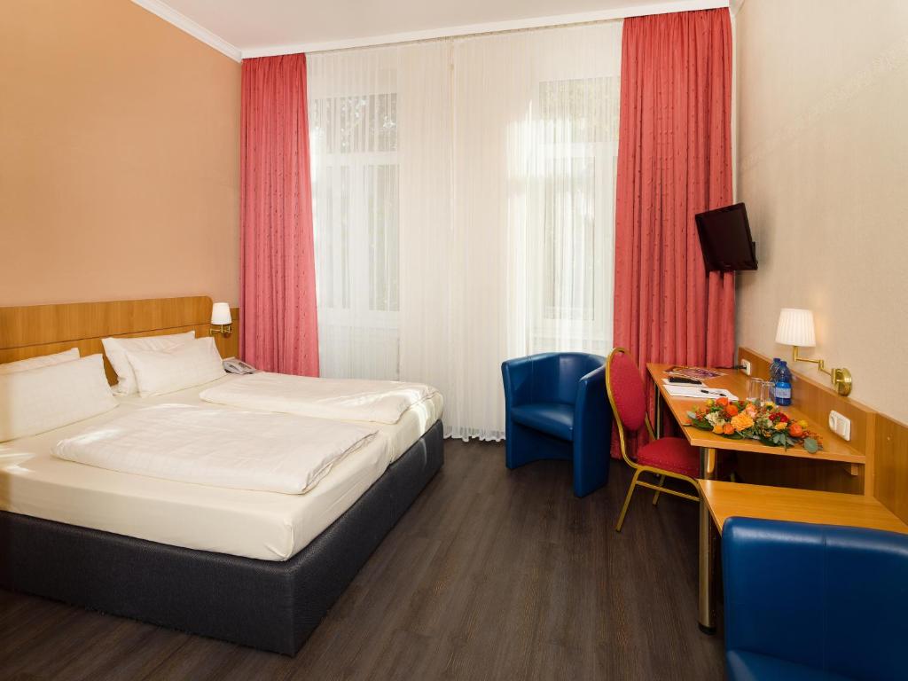 美因茨肯尼格索夫酒店的配有一张床和一张书桌的酒店客房