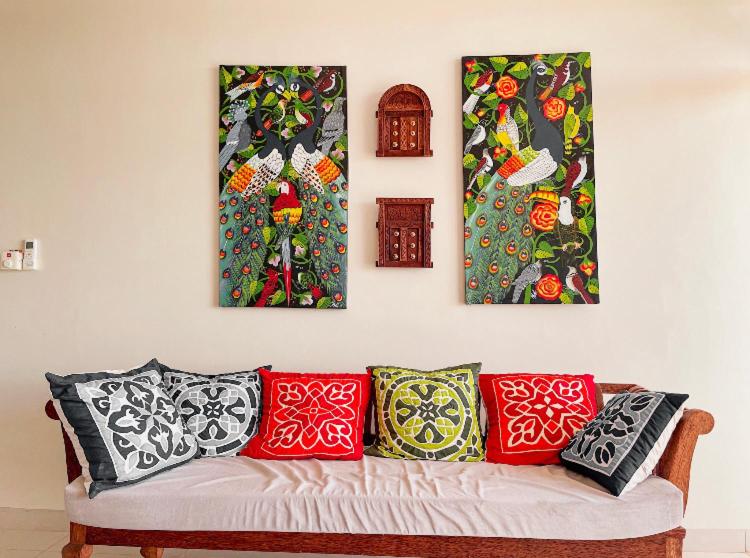 Mwembe MaepeBest View Malindi Guest House的沙发上墙上的三幅画