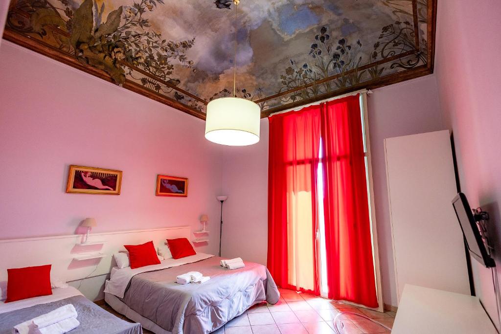 卡塔尼亚Promenade B&B的一间卧室设有两张床,天花板上绘有绘画作品