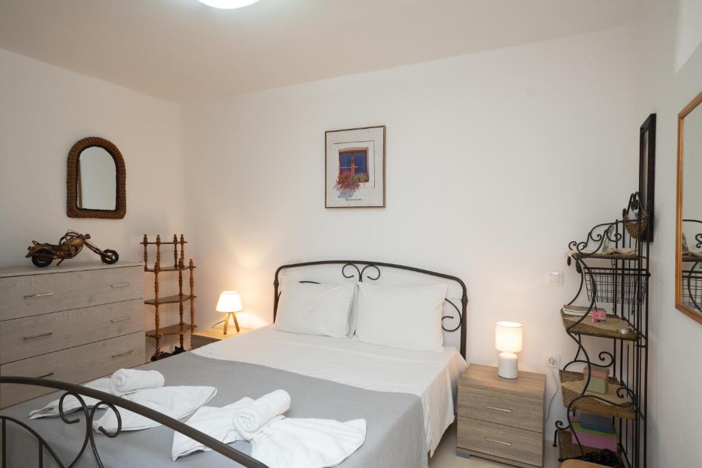 阿格拉瑞Spilia Apartments & Suites Mykonos的一间卧室配有带白色床单和白色枕头的床。