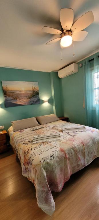 多列毛利诺斯Semi-detached Adosado con Encanto -130 m2 - WiFi 600 Mb - Piscina Comunitaria - Patio Privado的一间卧室配有一张带吊扇的床