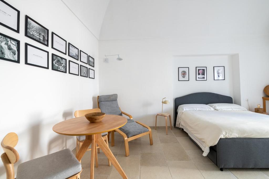佩斯基奇Minimà Peschici的卧室配有一张床和一张桌子及椅子