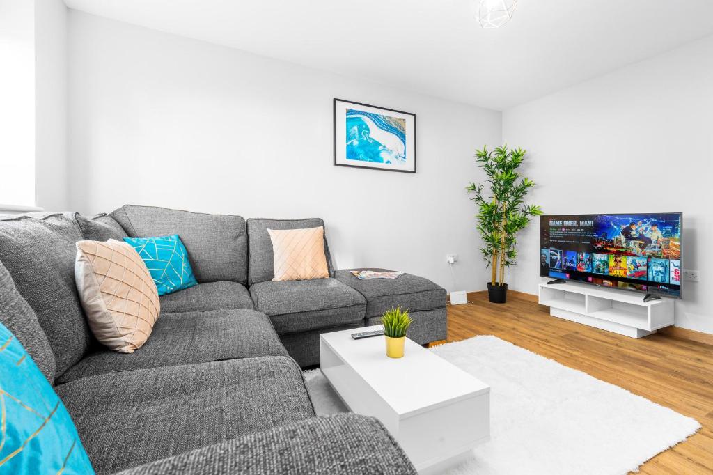 Modern 2 Bedroom Apartment - Off-street Parking - Top Rated - 1aS的客厅配有灰色的沙发和电视