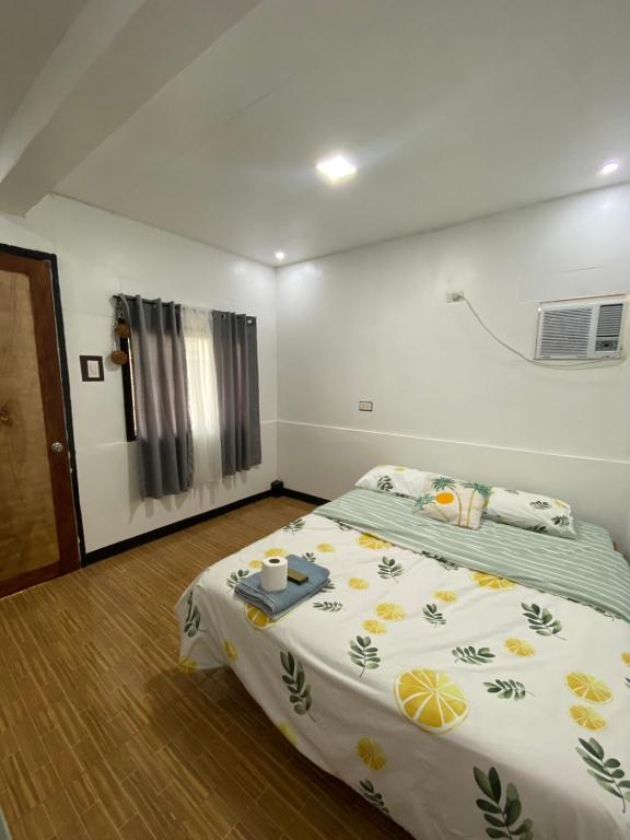 莫阿尔博阿TopBudz Hostel Panagsama Moalboal Couple的小卧室配有一张床和床罩