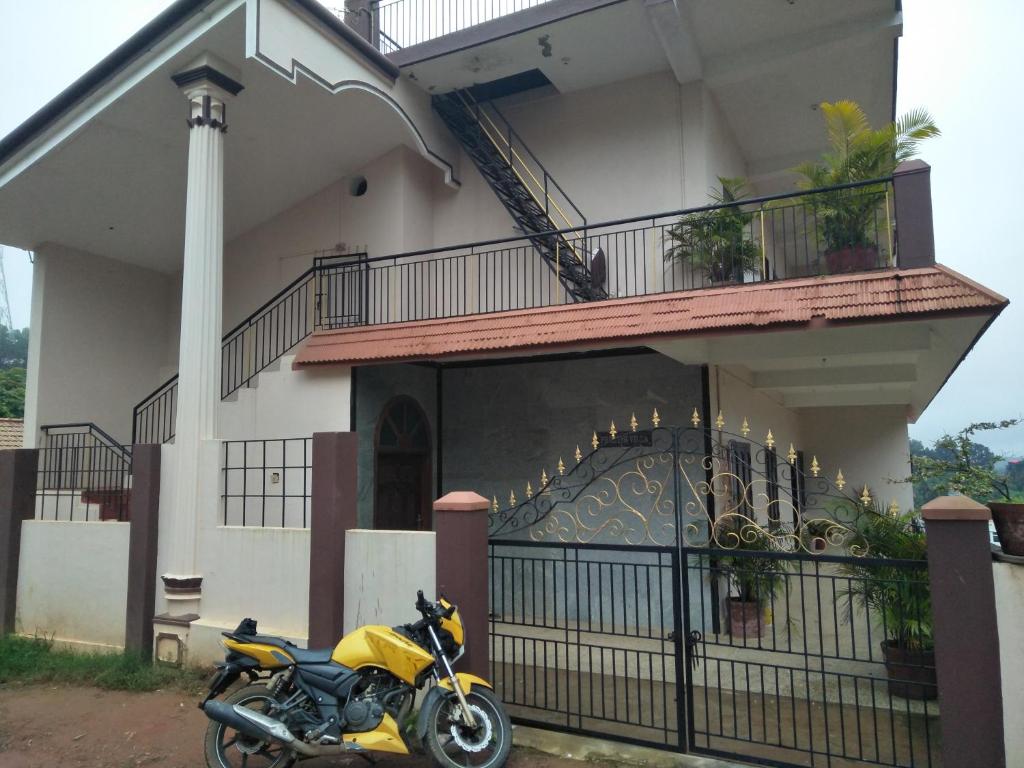 马迪凯里Coorg villas apartment stay的停在大楼前的黄色摩托车