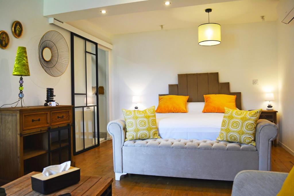 圣阿韦尔坦Manoir Drissia - Tours Centre, France的一间卧室配有黄色和橙色枕头的床