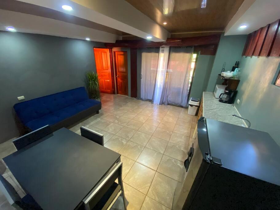 卡里略Tabaco Lodge #2 a solo 5 minutos de Playa Carrillo的客厅配有蓝色的沙发和桌子