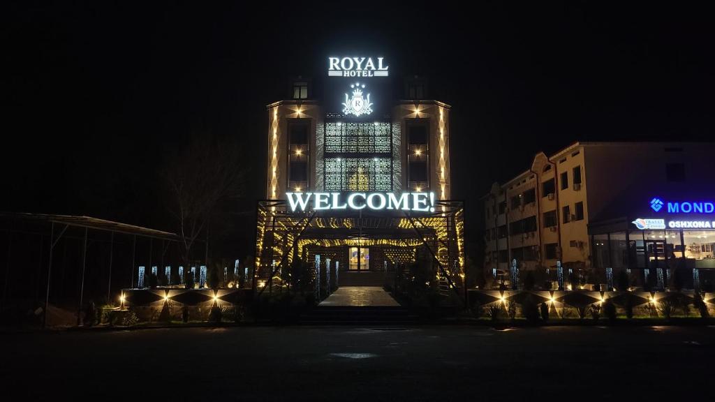 纳沃伊Royal Hotel的一座晚上在上面贴有欢迎标志的建筑