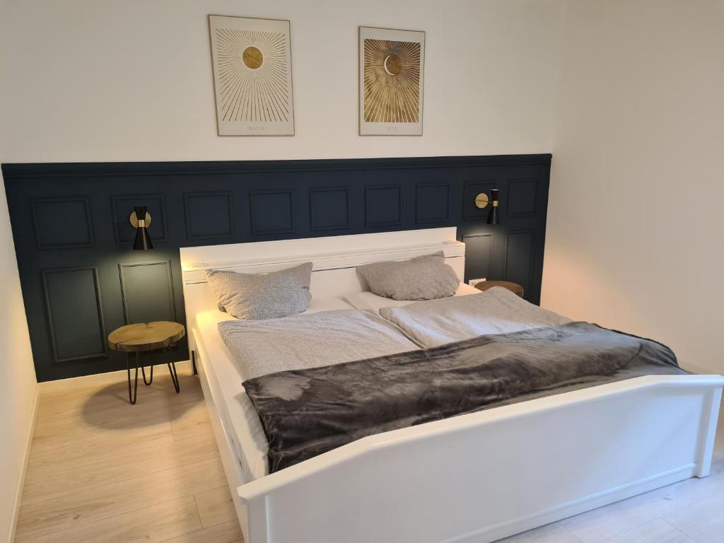 拜尔施泰因FeWo Alt Beilstein的一间卧室配有一张白色的床和黑色床头板