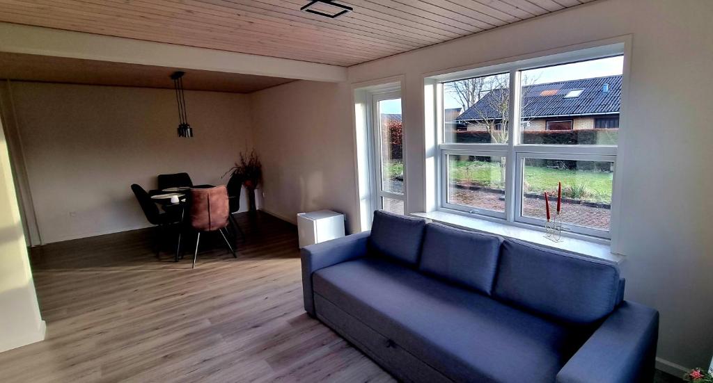 RødekroAnnes Hus的客厅配有蓝色的沙发和桌子