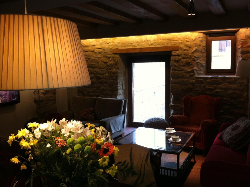 蓬特拉雷纳埃尔奇科酒店的客厅配有一张带花束的桌子