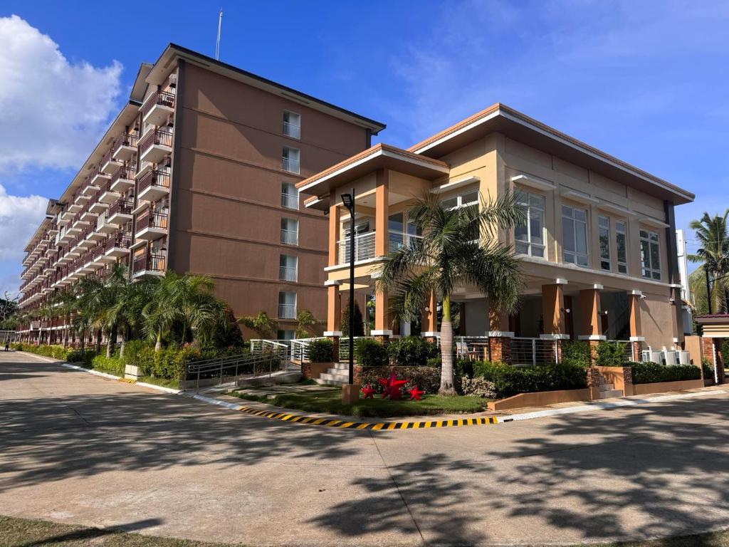 公主港Cozy Condo Palawan的前面有棕榈树的建筑