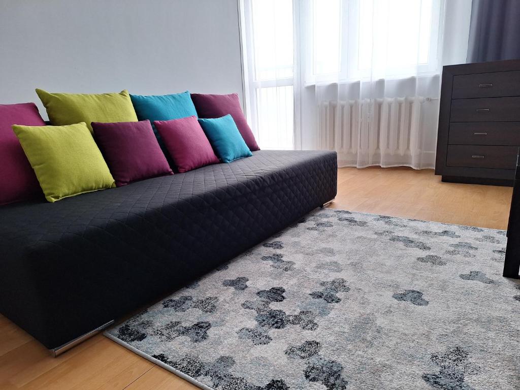 什切青Turkusowa Apartament的客厅里一张带色彩缤纷枕头的沙发