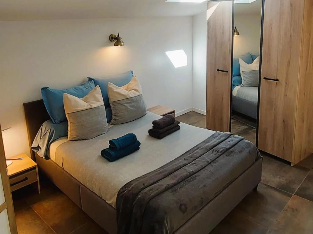 格雷乌莱班Dépendance Spacieux Duplex 50 M2 Classé 3 étoiles sans vis-à-vis的一间卧室配有一张带蓝色枕头和镜子的床
