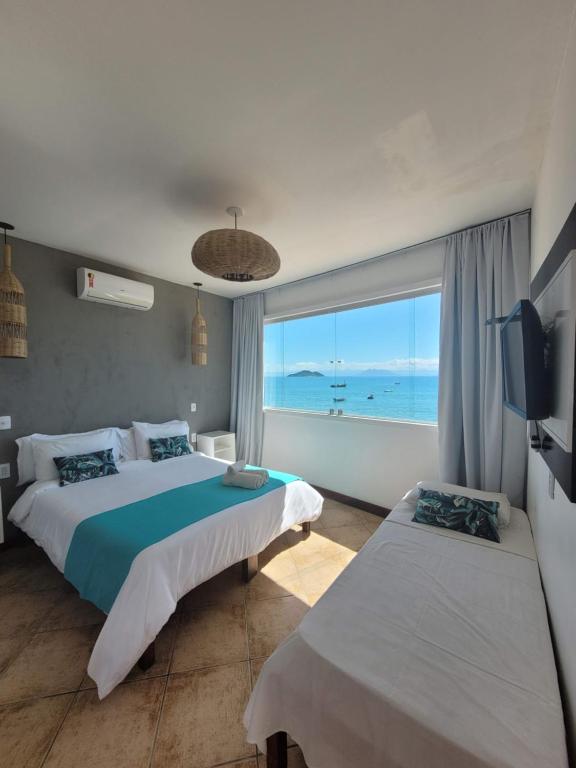 布希奥斯Bamboo Búzios Hostel的一间带两张床的卧室,享有海景