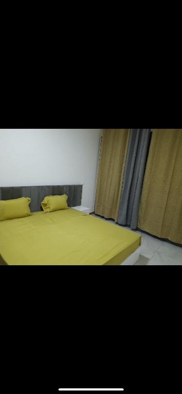 São TiagoPensão lopes的一间卧室配有黄色的床和两个枕头