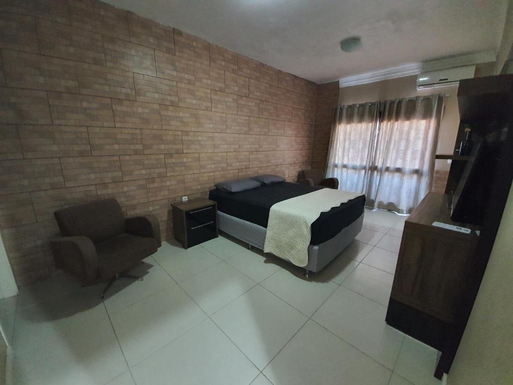 阿雷格里港Casa-Ampla Porto Alegre-RS的一间卧室配有一张床和一把椅子