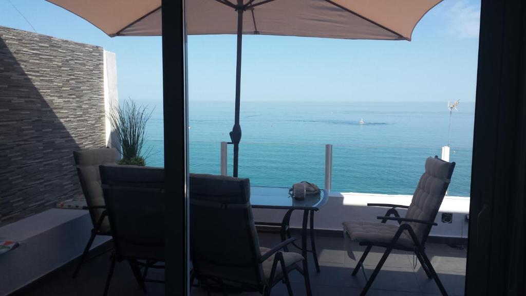 多列毛利诺斯海滨简易别墅公寓的一张桌子和椅子,享有海景