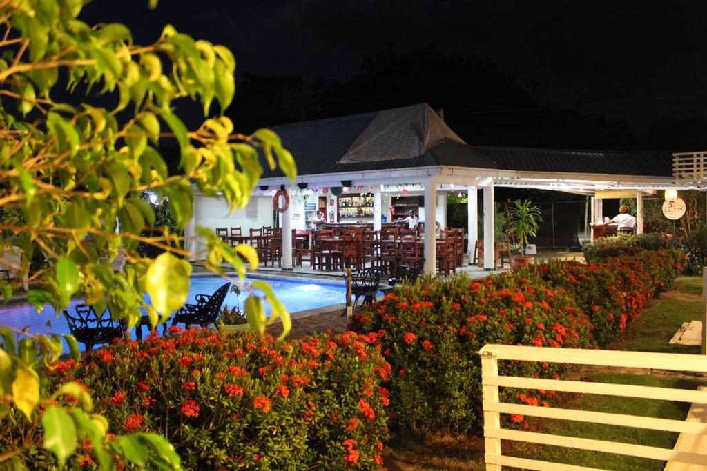 El LimónLUTIX HOTELS的一个带游泳池、桌椅和鲜花的度假村