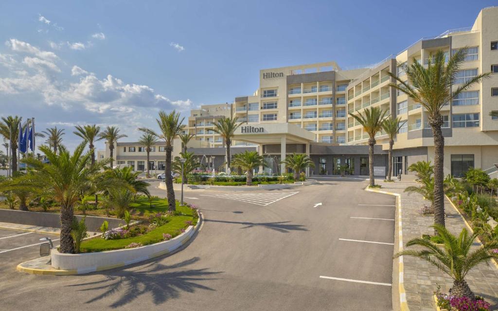 莫纳斯提尔Hilton Skanes Monastir Beach Resort的酒店前面的一个空停车位