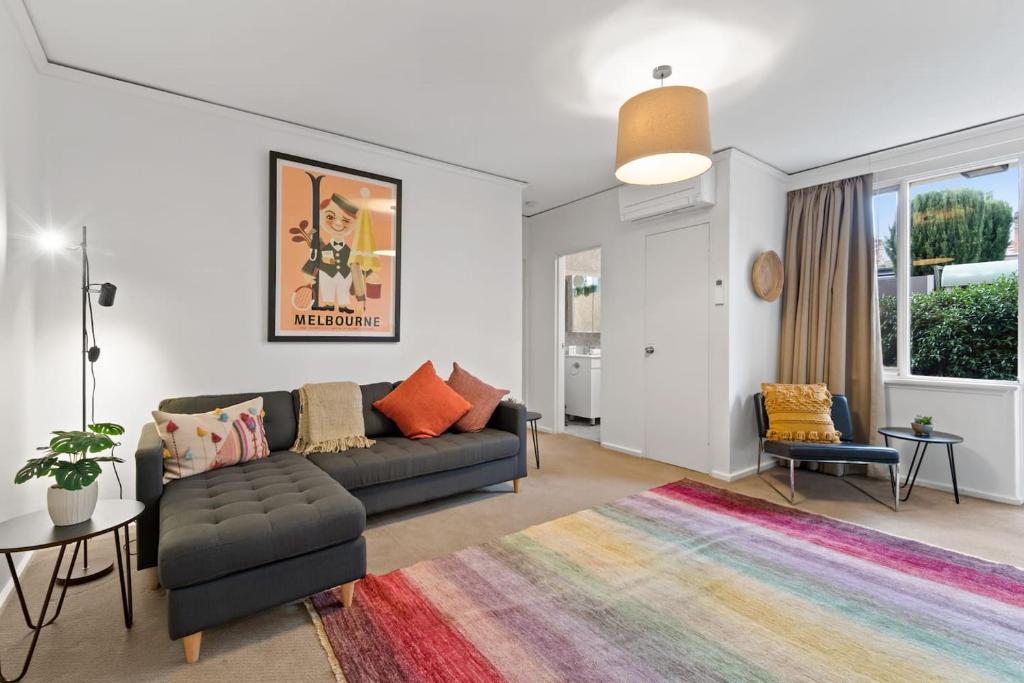 墨尔本Urban Retro - Experience Vibrant Courtyard Charm的客厅配有沙发和色彩缤纷的地毯