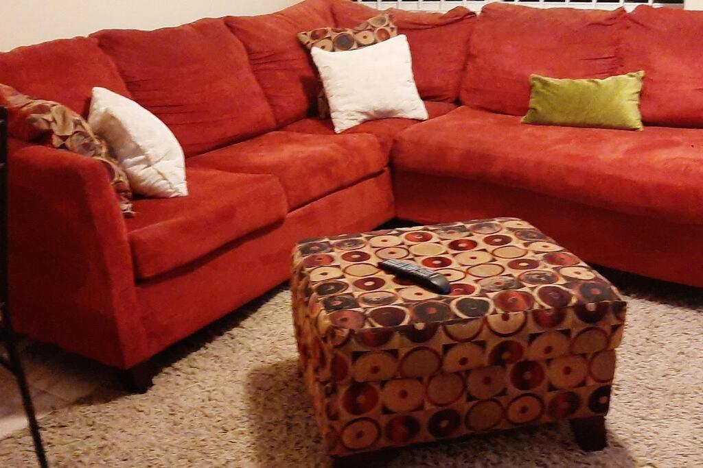 拿骚The sweet Oasis 1 bedroom Apartment的客厅里设有一张红色的沙发和一个搁脚凳