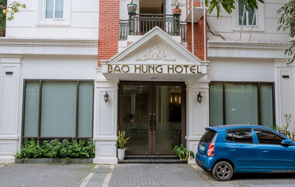 清化Bảo Hưng Hotel的停在一个挂袋酒店前的蓝色汽车