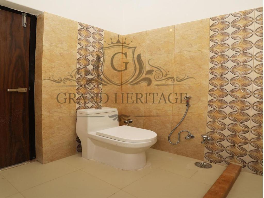 斋沙默尔Hotel Grand Heritage Jaisalmer的一间带卫生间的浴室和墙上的标志