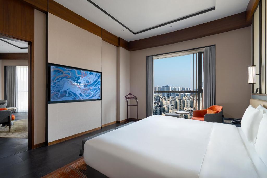 济南济南君廷酒店的一间卧室设有一张大床和一个大窗户