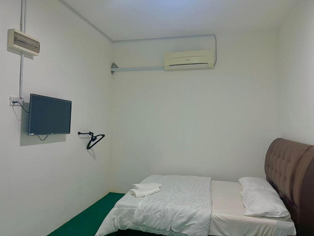 Kampong Tebing RabakHASD GUESTHOUSE的小房间设有床铺和电视