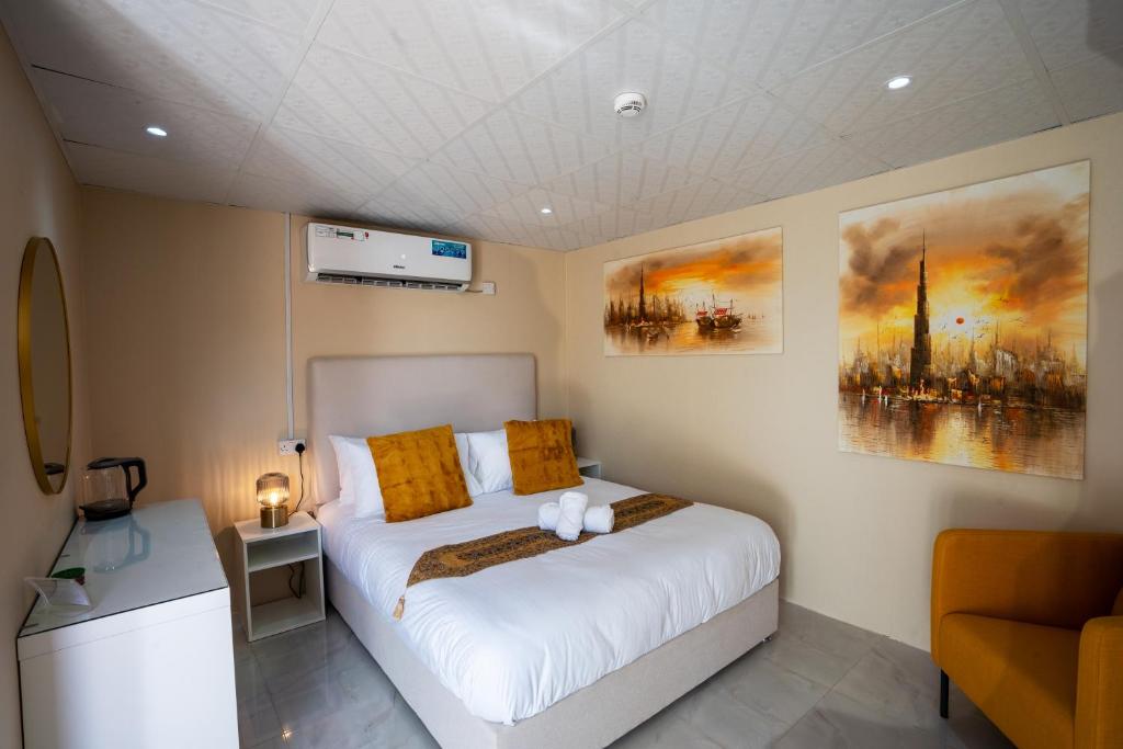 HunaywahDesert Safari Overnight Experience "Modern room with AC & Entertainment"的卧室配有带橙色枕头的大型白色床