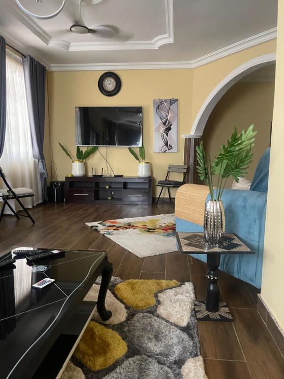 阿克拉Coolzzy GM247 Homes-Accra Kwabenya Villas的带沙发和电视的客厅