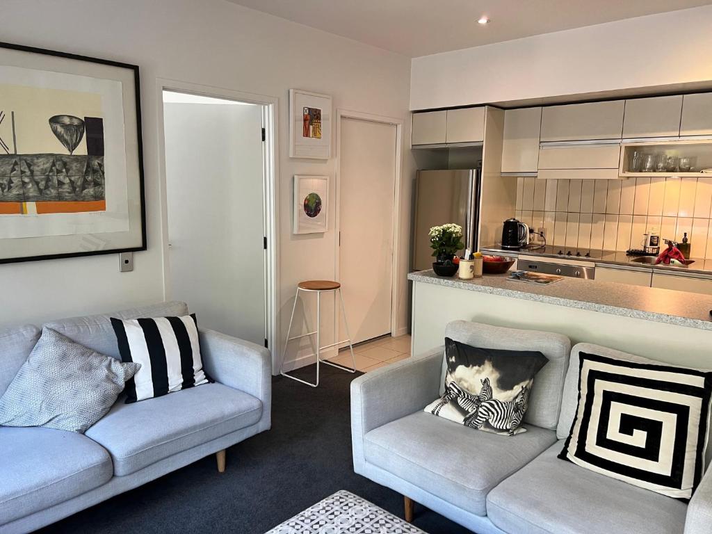 奥克兰Lovely 2 bedrm apartment in Auckland's viaduct的一间带两张沙发的客厅和一间厨房