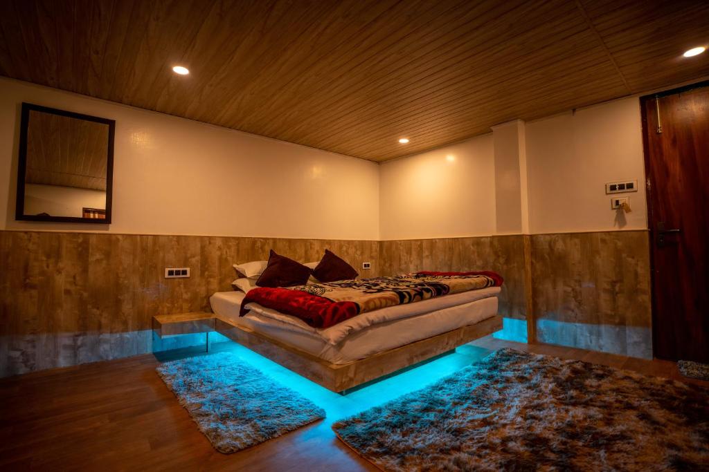 大吉岭Darjeeling Guest House Deluxe的一间设有床铺的卧室,位于蓝色灯光的房间