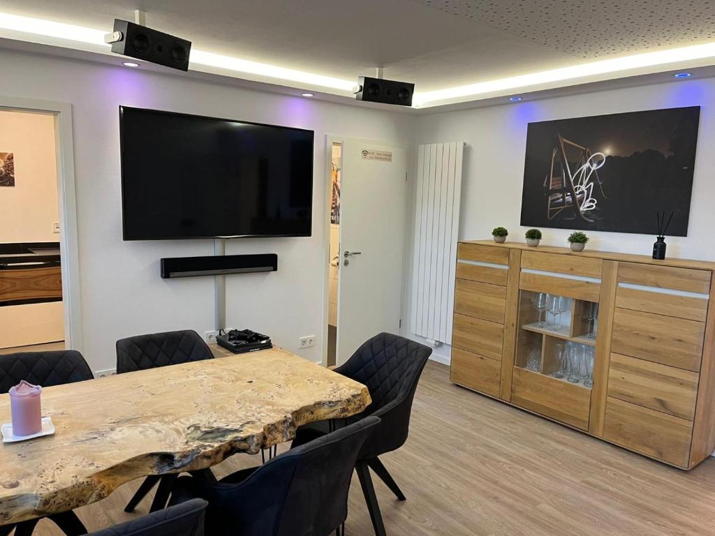斯图加特Porschenahe Wohung的一间会议室,配有桌子和一台平面电视