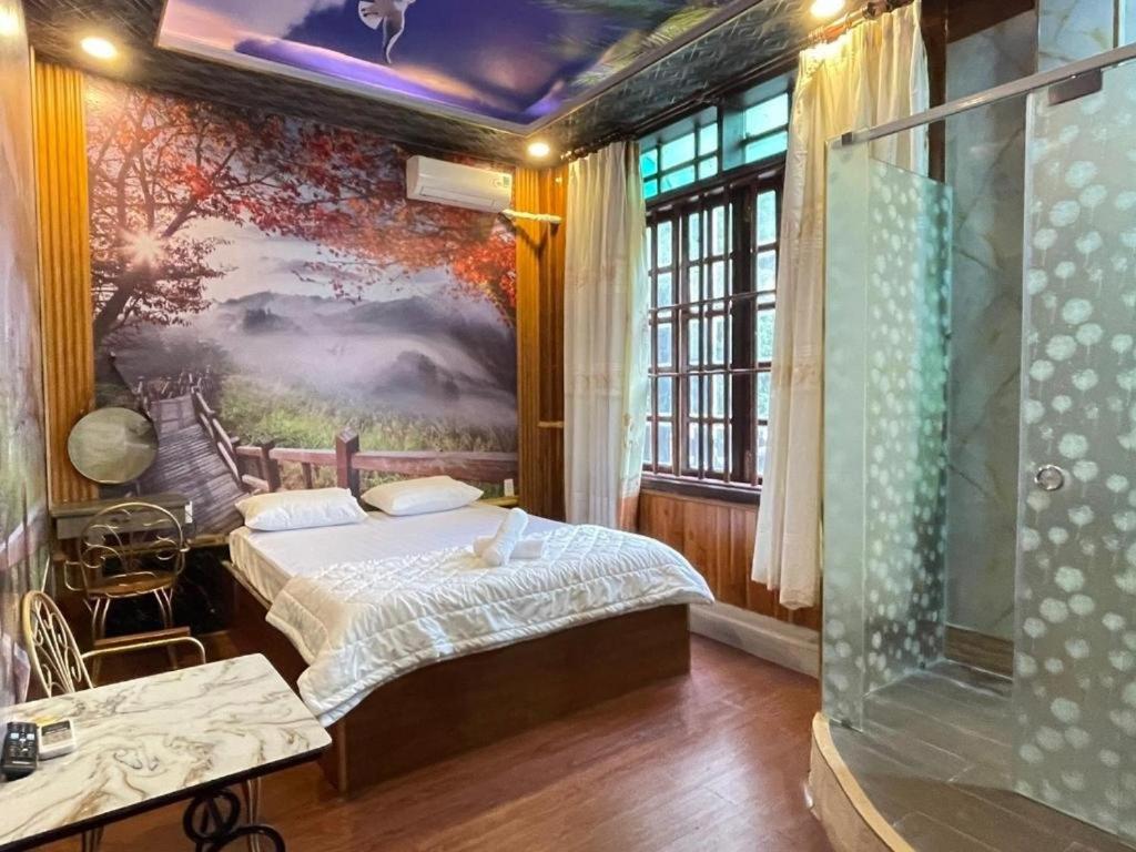 Ấp Phú ThọHoàng Gia Hotel - 1224 CMT8 Bình Dương - by Bay Luxury的卧室配有一张床,墙上挂有绘画作品