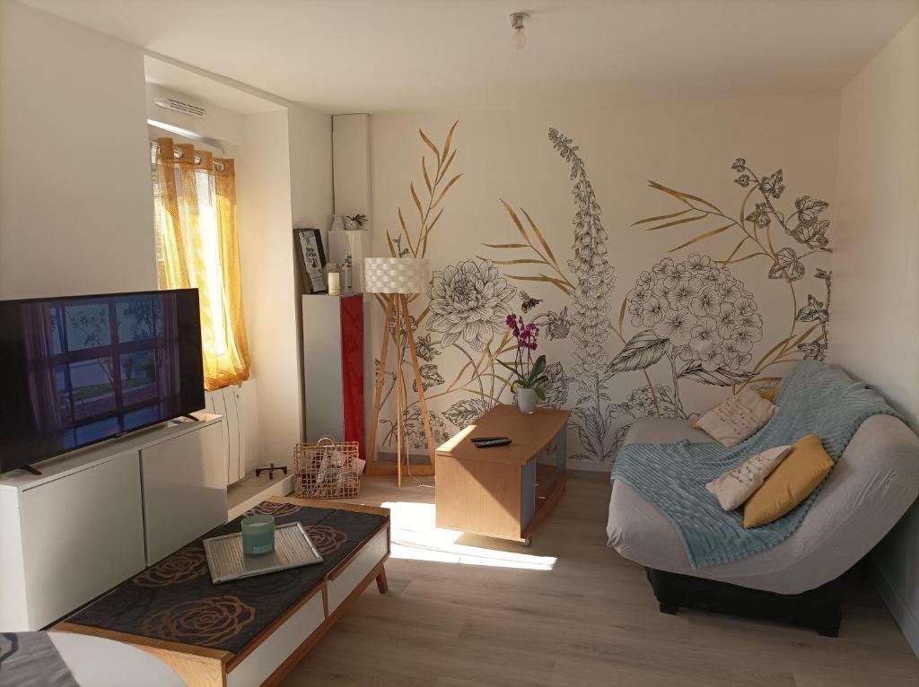 拉加西利Panoramique floral的带沙发和电视的客厅