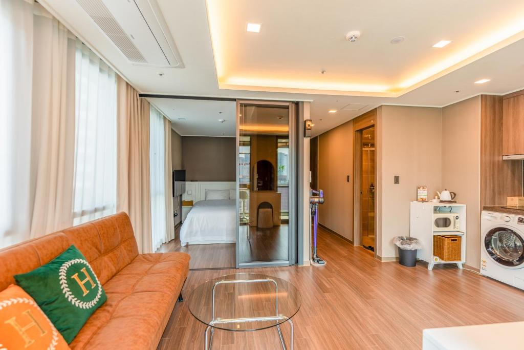 釜山Haeundae Family Hotel ARBOL Sunny#ocean view的客厅配有沙发和1张床