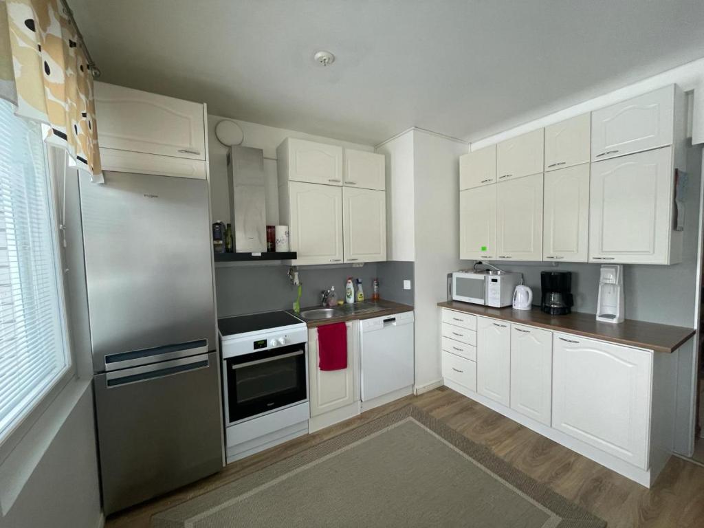 肯佩莱Kempele city center的厨房配有白色橱柜和不锈钢冰箱