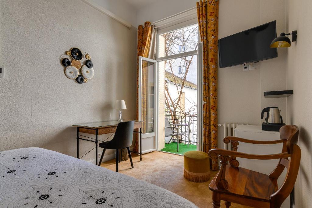 塔布亨利四世酒店的一间卧室配有一张床、一张桌子和一个窗户。