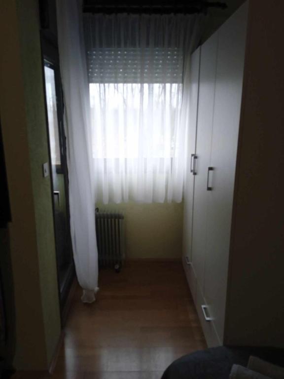 BelišćeKrpan的走廊上设有白色窗帘和窗户